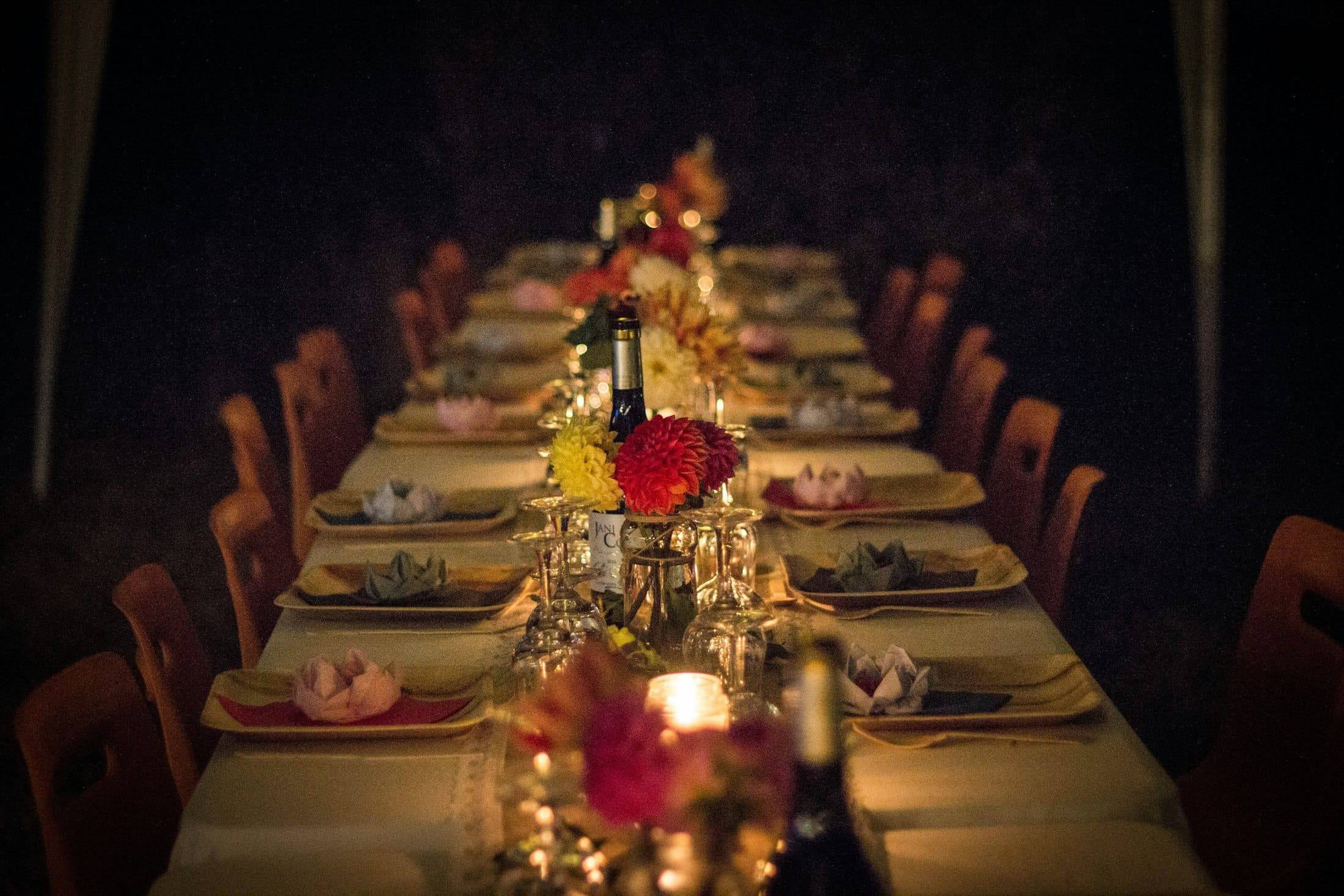 Mesa larga de cena con velas y flores de noche