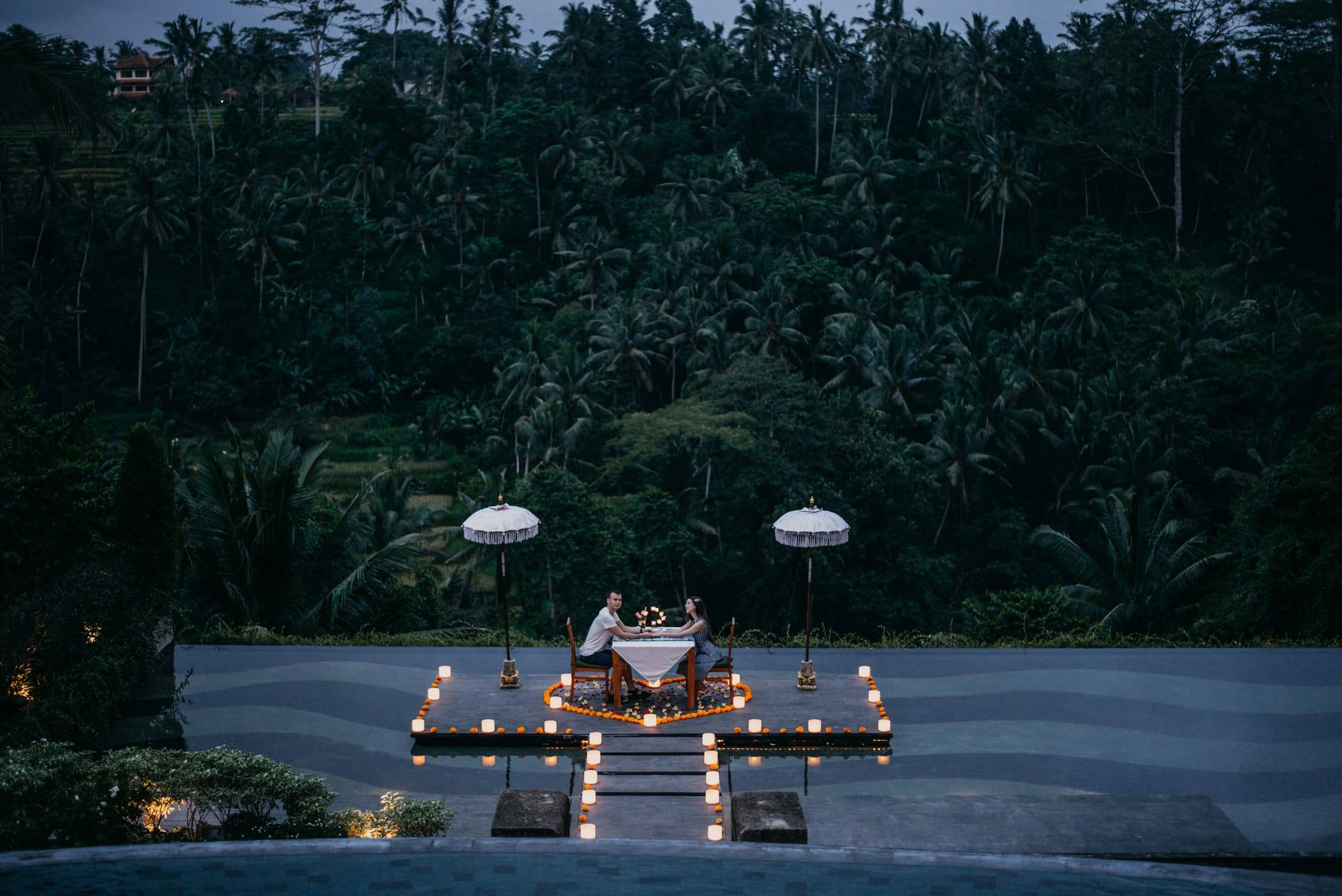 Cena a la luz de las velas para dos en una terraza frente a la selva al atardecer